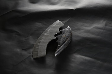 Knife made of Damascus steel with a wooden handle on a white background