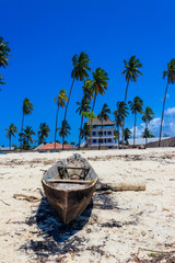 Old wooden boat ashore on tropical sandy Nungwi beach in the Indian ocean on Zanzibar, Tanzania