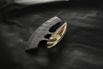 Knife made of Damascus steel with a wooden handle on a white background