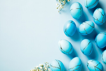 Elegant blue Easter eggs with marble texture on light blue background. Flat lay, top view, copy space.