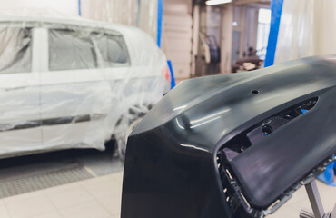 Auto mechanic preparing the car for paint job by applying polish with the power buffer machine