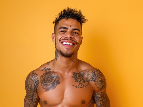 handsome happy man with tattoos on yellow background