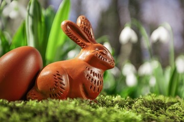Easter chocolate bunny or rabbits with spring flower in forest