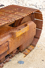 Detail of an old and rusty excavator abandoned on the beach