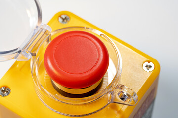 Detailed closeup view of a red emergency stop button industrial machine safety off switch, red...