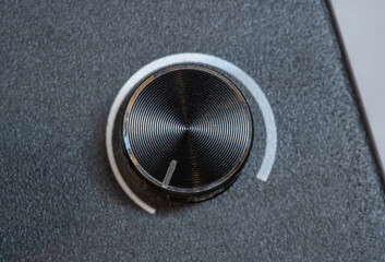 Detailed close-up of a textured generic grey black silver electronic rotary dial, part of a digital...