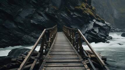 a wooden bridge over a body of water next to a rocky cliff with water rushing down the side of it.