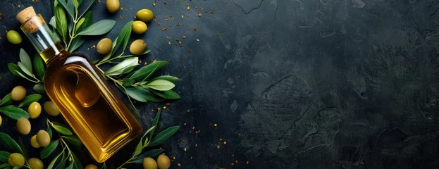  A bottle of fresh olive oil sits on a beautiful dark background, surrounded by olives and leaves. © FryArt Studio