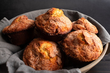 Banana Cinnamon Muffins Served in a Large Bowl: Close-up view of a linen-lined basket full of freshly baked breakfast muffins
