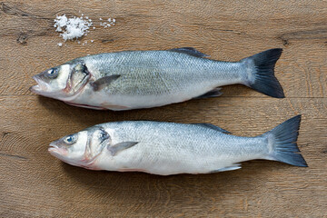 Wolfsbarsch Loup de Mere, frischer Fisch zur Zubereitung auf Holzhintergrund