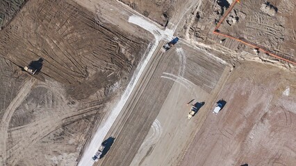 Earthmoving equipment. Aerial view of a large construction site with several earthmoving machines.