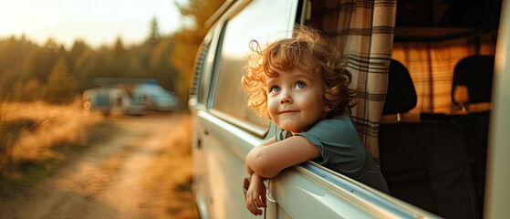 Child looks out of the window of campvan on the road