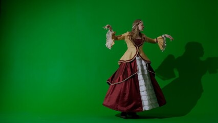 Woman in ancient outfit on the chroma key green screen. Woman in renaissance style dress gracefully dancing. © kinomaster