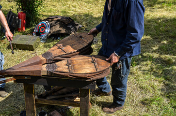 Blacksmith with the ancient bellows blowing the coals for forging during the folk festival
