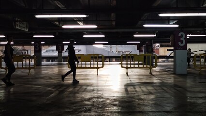 people walk through the closed parking. - obrazy, fototapety, plakaty