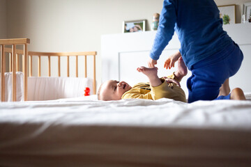 side view of two children playing with each other on the parent's bed