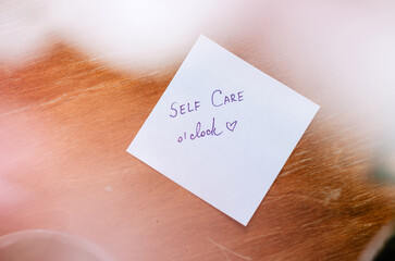 Self care o'clock message handwritten on post it