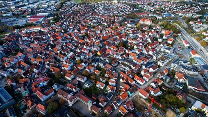 Aerial around the old town of the city Metzingen in Germany on a sunny afternoon in autumn	