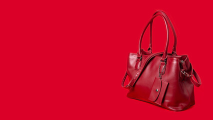 Red women's leather bag on a red background. Banner, space for text.