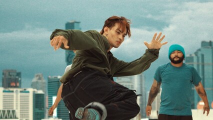 Professional asian break dancer practice B boy dance while multicultural friends at rooftop. Young modern dancing group doing hip hop movement. Style,fashion,action. Outdoor sport 2024. Endeavor.