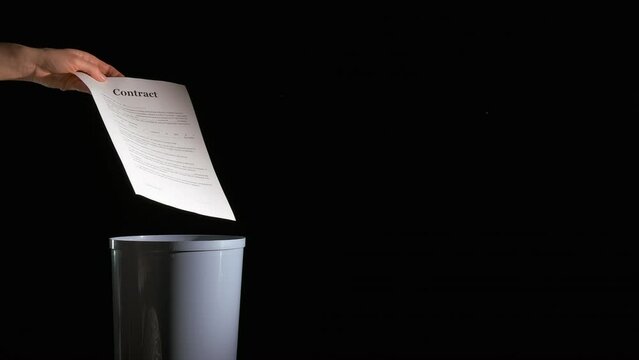 Business papers fall into bin. A office worker throw the contracts papers into bin on the black background.