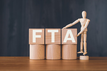 There is wood cube with the word FTA. It is an abbreviation for Free Trade Agreement as...
