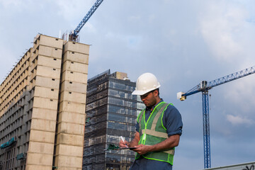 Latin construction worker man looking documents in construction site in sunny day