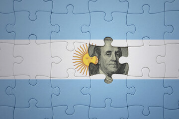 puzzle with the national flag of argentina and usa dollar banknote. finance concept
