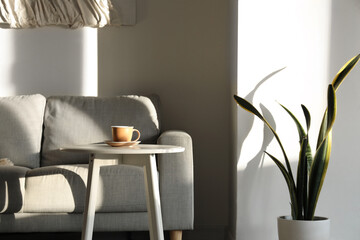 Interior of light apartment with cup of fresh espresso on coffee table