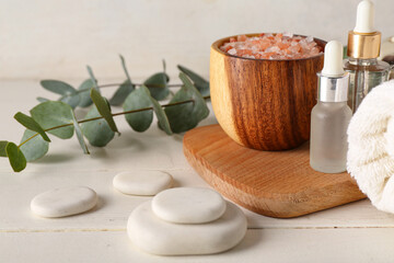 Spa composition with eucalyptus branches on light wooden table
