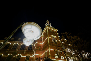 A street lamp shines against the background of a decorated building.