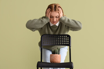 Mature woman and chair with cactus green background. Hemorrhoids concept