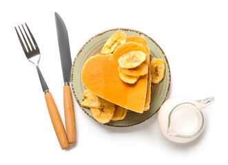 Plate with tasty pancakes in shape of heart, dried banana and milk on white background. Valentine's Day celebration