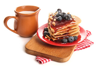 Plate with tasty pancakes in shape of heart, blueberry and milk on white background. Valentine's Day celebration