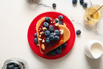 Plate with tasty pancakes in shape of heart, blueberry and jam on light background. Valentine's Day...