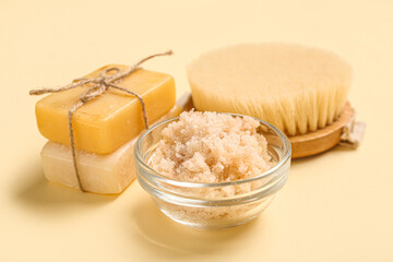 Scrub with soap and brush on light yellow background. Body massage concept