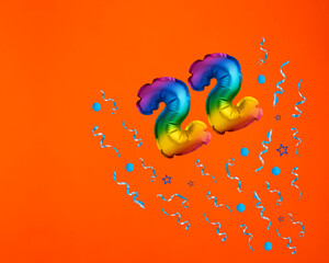 Confetti explosion with number 22 balloon - Celebration on orange background. Birthday card