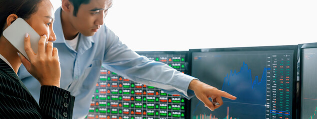 Smart cooperative male trader points the growth analysis stock market graph displayed on computer...