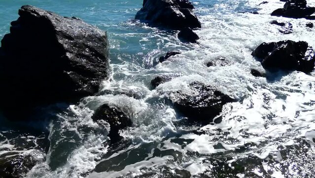 Oleaje de verano sobre las rocas de la playa - Mar de color zafiro brillante