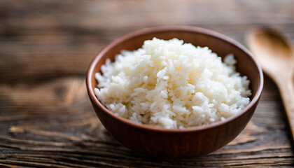 Cooked rice in bowl on wooden background, symbolizing nutrition, sustenance, Asian cuisine. Copy space for food-related concepts
