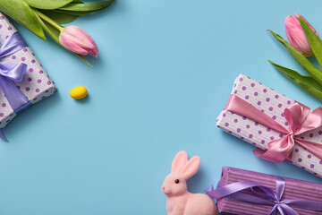 Gift boxes with Easter bunny and tulip flowers on blue background