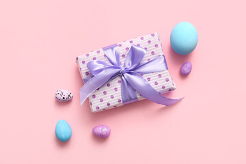 Easter eggs with gift box on pink background