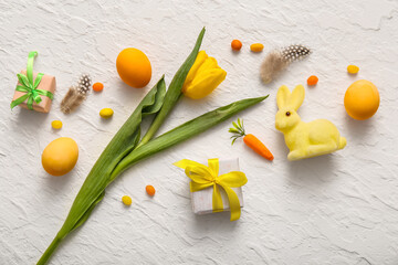 Easter eggs with gift boxes, tulip flower and bunny on white background