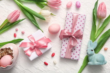 Easter eggs with gift boxes, tulip flowers and bunny on white background