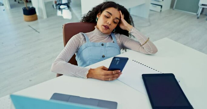 Laptop, phone and bored with business woman at desk in office with fatigue or exhaustion from work. Computer, burnout or social media distraction with app and frustrated young employee in workplace