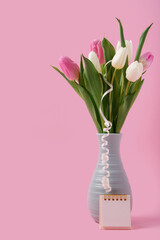 Vase with beautiful tulips and calendar on pink background. International Women's Day