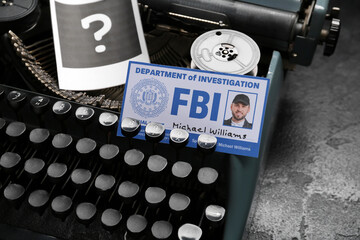 Retro typewriter, document of FBI agent and question mark on dark background, closeup