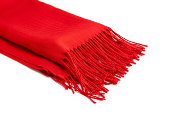 A red scarf made of thin fabric with fringes at the ends lies on a white background. The color of...