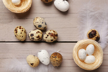 Nest with Easter eggs and feathers on grey wooden background