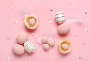 Composition with painted Easter eggs and nests on pink background